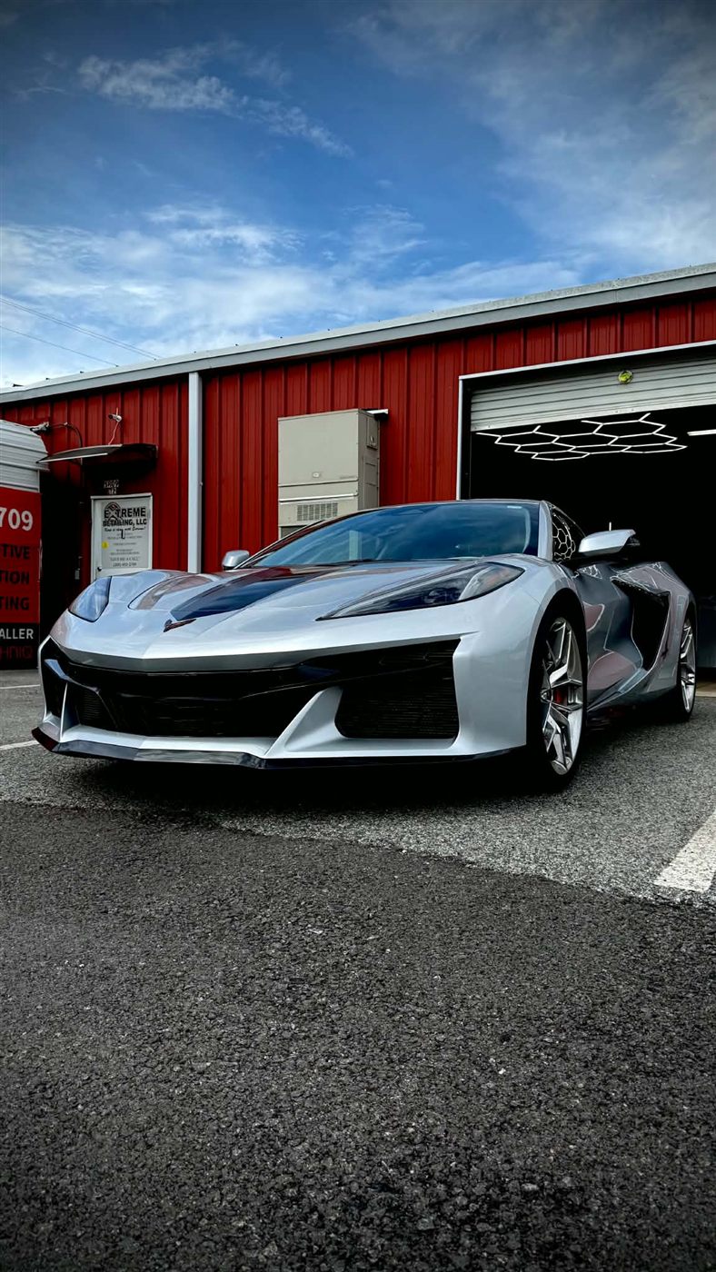 Silver Corvette Z06 in front of the shop