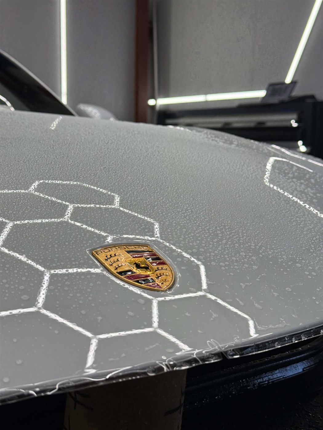 STEK paint protection film being installed on a Porsche hood